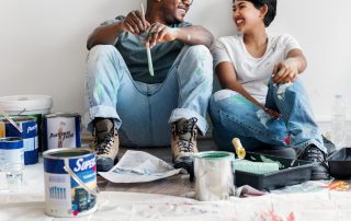 man-and-woman-smiling-while-painting-home-renovation